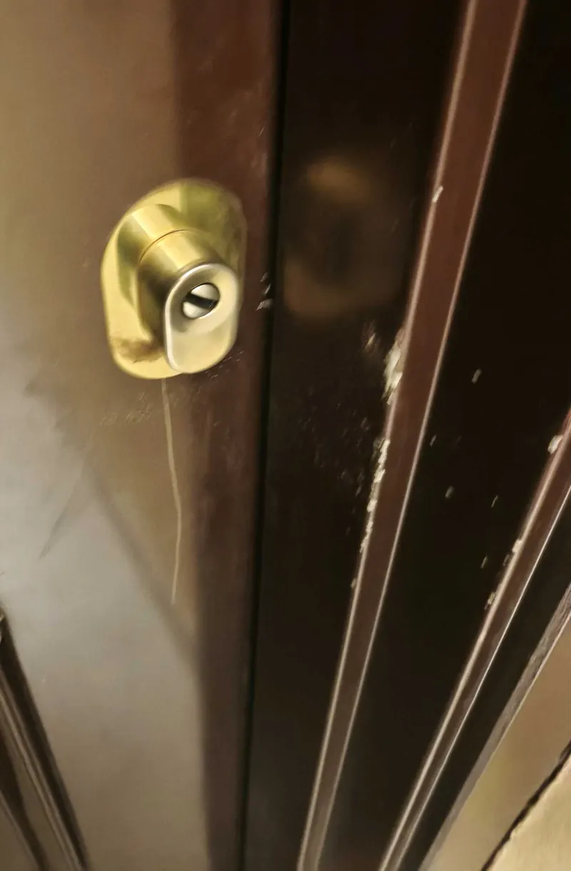 Cylindre doré sur une porte d'entrée en bois sombre – photo d'intervention, serrurier Bezons