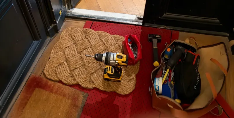 Perceuse et outils de serrurier posés devant une porte d'entrée – photo d'intervention, serrurier Franconville