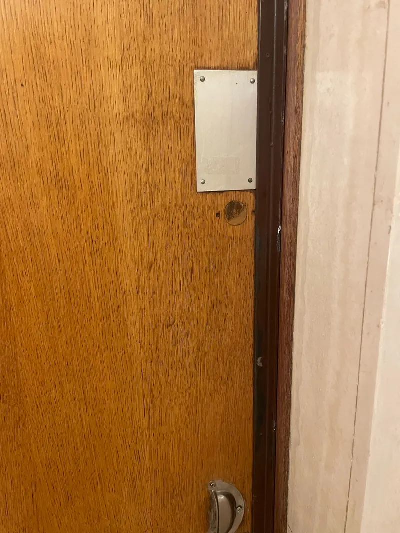 Porte en bois avec plaque de renfort au-dessus de la serrure – photo d'intervention, serrurier Paris 2e