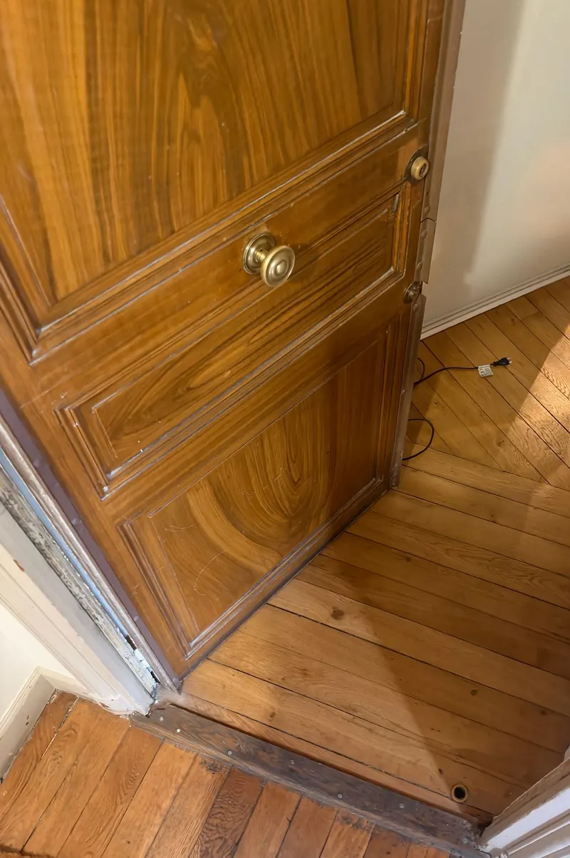 Porte palière en bois vernis, ouverte sur le palier, photo d'une intervention de France Serrures