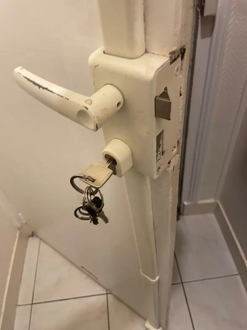 Serrure en applique et clés sur une porte intérieure blanche – photo d'intervention, serrurier Eaubonne